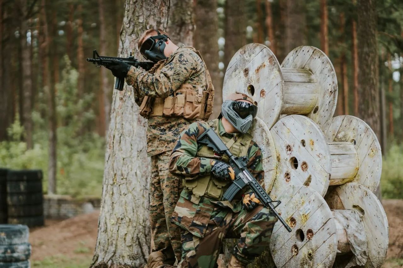 airsoft spēlētājs ar repliku un pilnu sejas aizsardzību