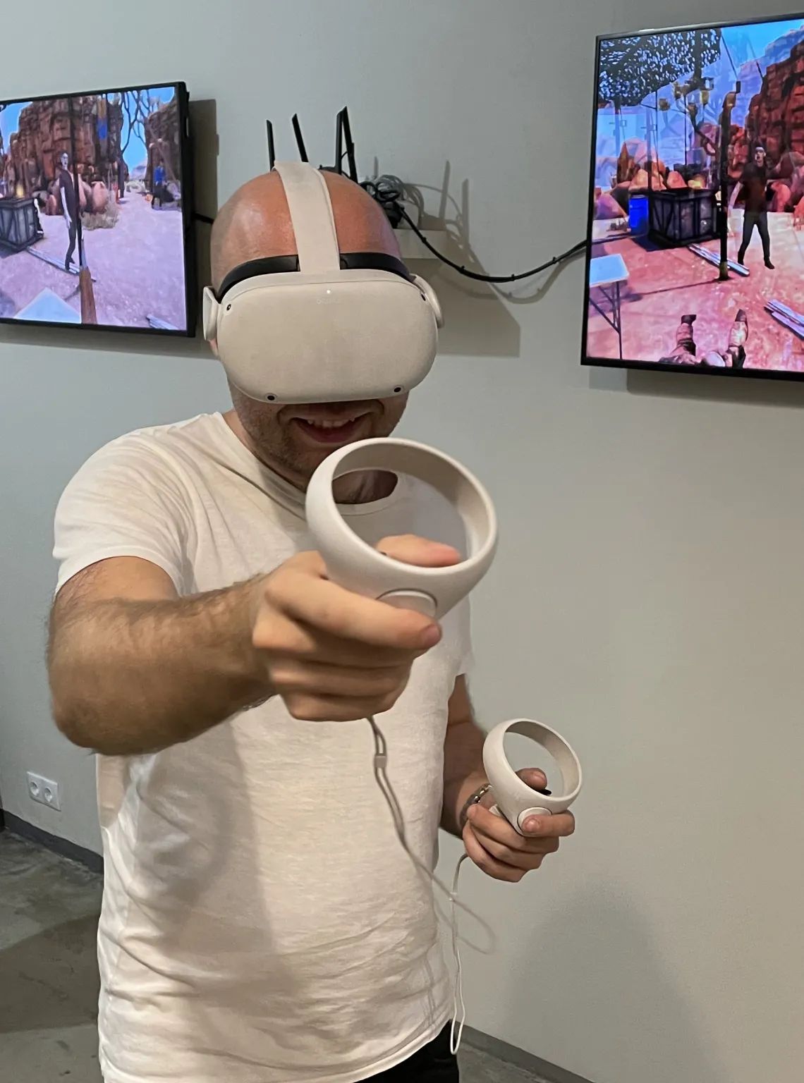 Vīrietis spēlē virtuālās realitātes spēli ar VR brillēm un kontrolieriem