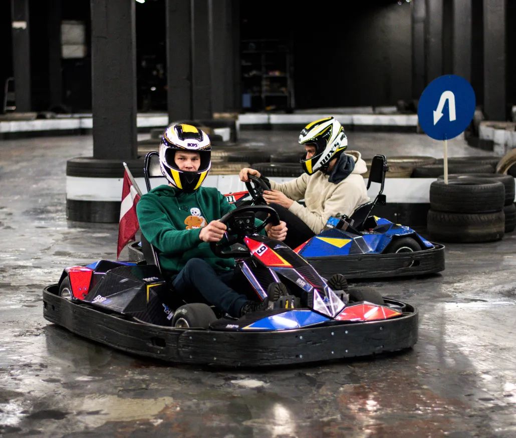 Divi braucēji sacenšas ar elektrokartingiem iekštelpu trasē