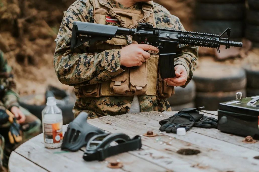 Airsofta replika un ekipējums uz galda blakus spēlētājam