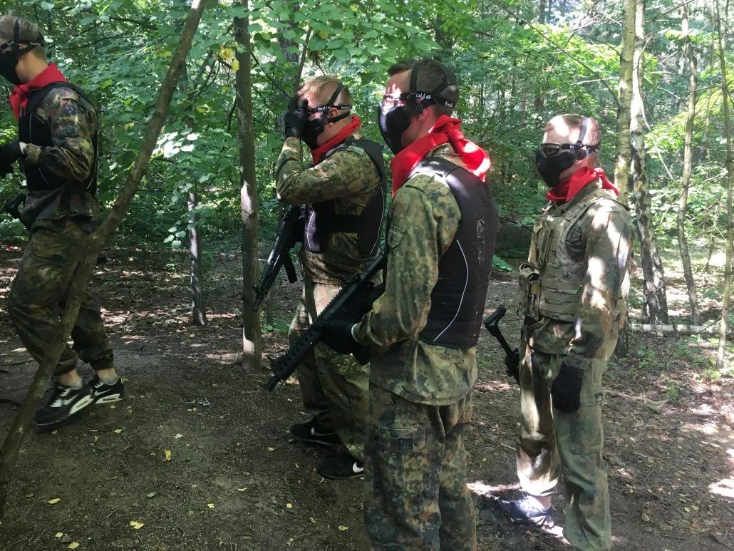 Airsofta spēlētāju grupa meža laukumā