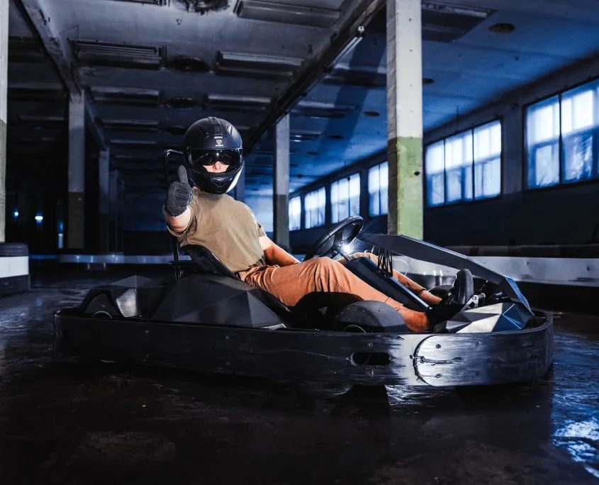 Bērns brauc ar elektrokartingu GUNSnLASERS iekštelpu trasē