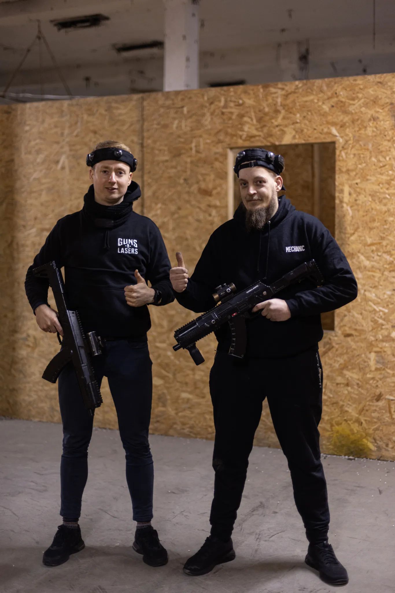 Divi vīrieši ar lāzertaga ieročiem pirms vecpuišu ballītes spēles