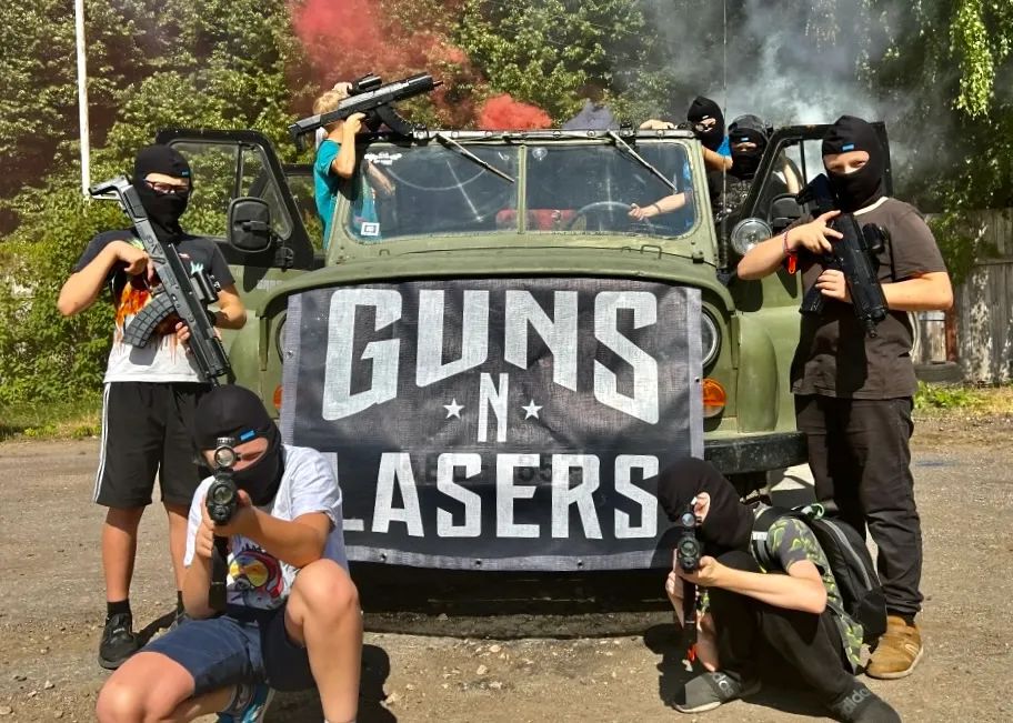 Lāzertaga komanda pozē pie GUNSnLASERS auto