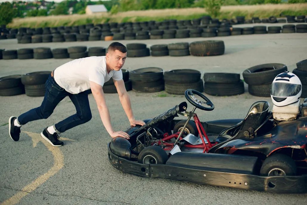 Darbinieks pārvieto benzīna kartingu āra trasē